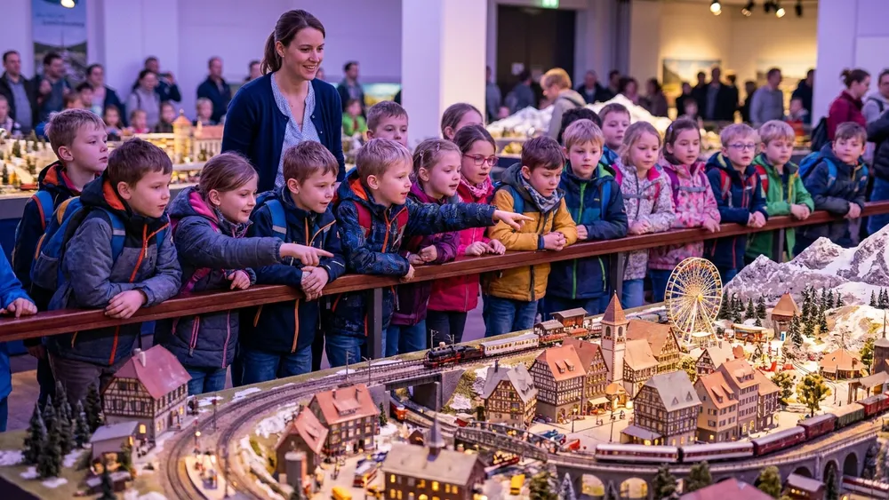 Miniatur Wunderland Hamburg – Schulklasse betrachtet ein detailliertes Modelllandschafts-Diorama mit Mini-Zügen
