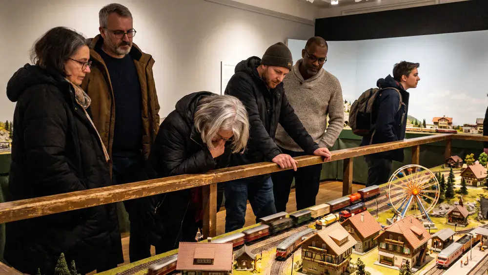 Miniatur Wunderland in Hamburg – Kollegen betrachten ein detailliertes Modelllandschafts-Diorama mit Mini-Zügen