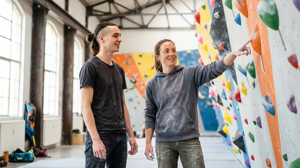 BETA Boulderhalle in Hannover – Zwei Personen vor einer bunten Boulderwand im umgebauten Güterbahnhof