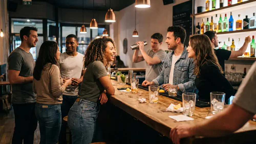 Cocktailkurs in Hannover – Kollegen mixen gemeinsam Cocktails an einer Bar unter Anleitung
