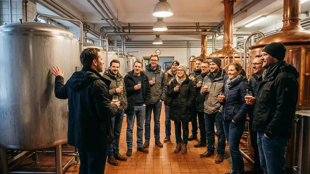 Brauereiführung in Hannover – Gruppe verkostet Bier vor Kupferkesseln in der Privatbrauerei Herrenhausen