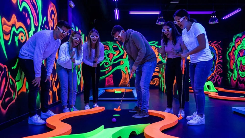Schwarzlicht Minigolf in Hannover – Gruppe spielt mit 3D-Brillen Minigolf in leuchtender Neonwelt