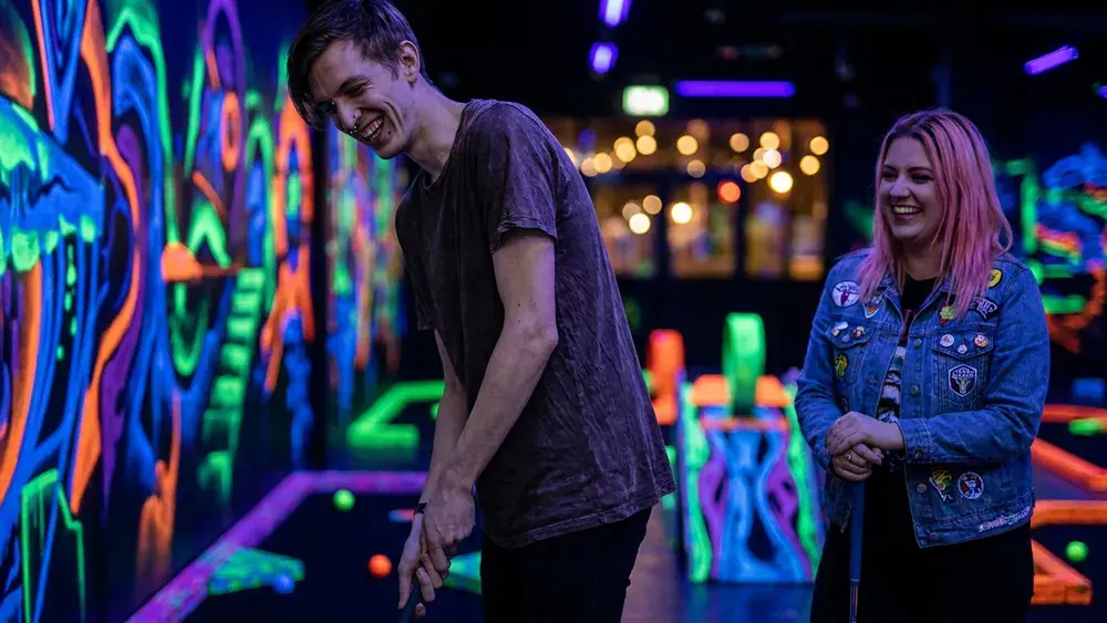 NeonGolf Schwarzlicht Minigolf in Hannover – Zwei Personen spielen unter UV-Licht