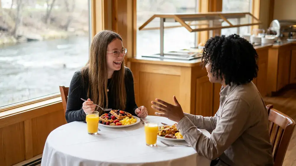 6Sinne Riverside in Hannover – Zwei Personen beim Sonntagsbrunch mit Waffeln und O-Saft am Fensterplatz