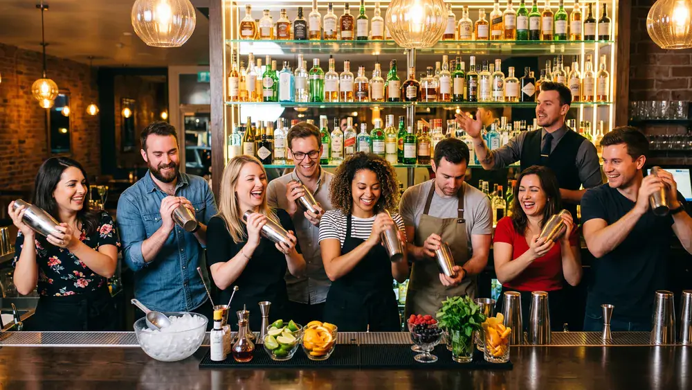 Cocktailkurs in Hannover – Kollegen mixen Cocktails an einer Bar unter Anleitung
