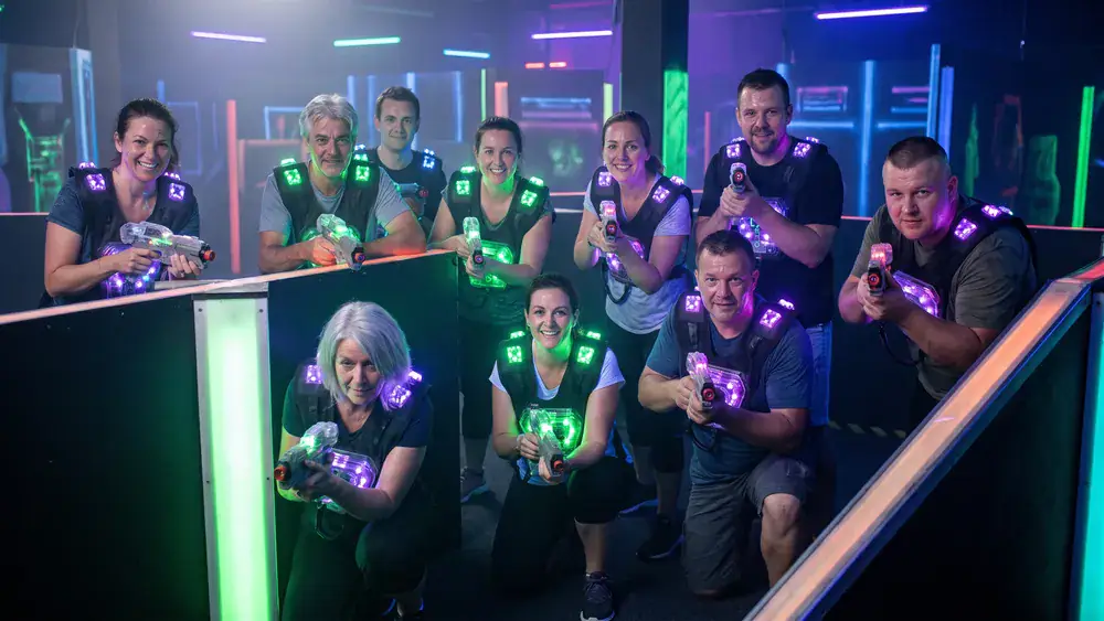 Lasertag bei funXperience Kassel – Kollegen feiern in tactical vests in einer dunklen Neon-Arena