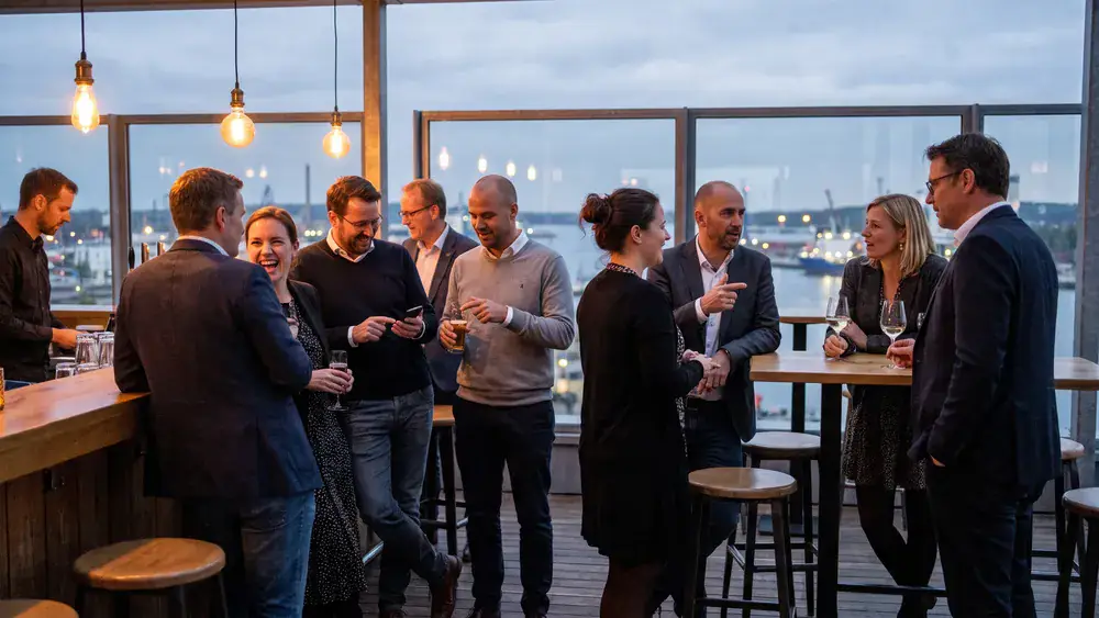 Deck 8 in Kiel – Kollegen trinken Cocktails an der Bar mit Panoramablick auf die Kieler Förde