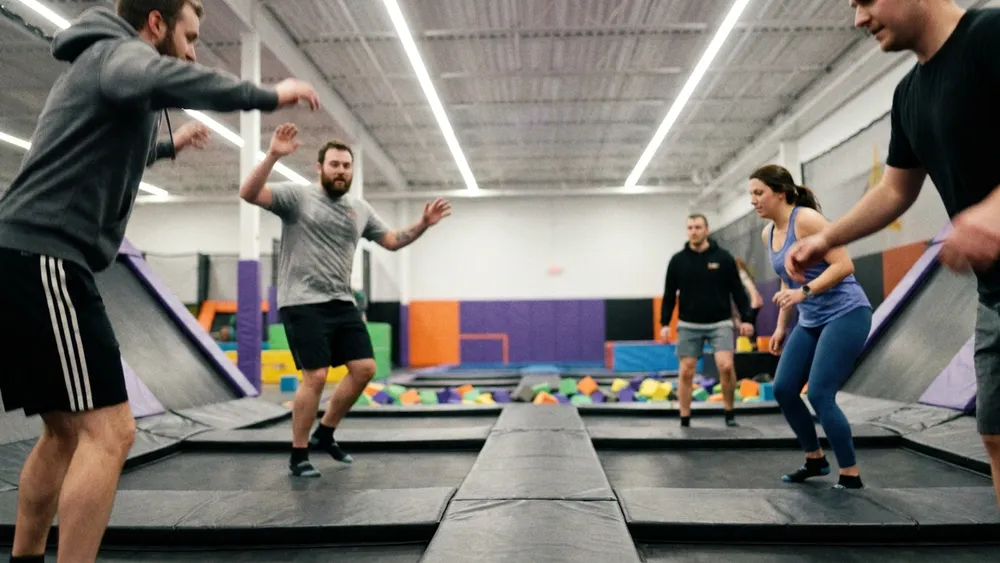 SPRUNG.RAUM Kiel – Gruppe springt gemeinsam auf Trampolinen in einem modernen Indoor-Park