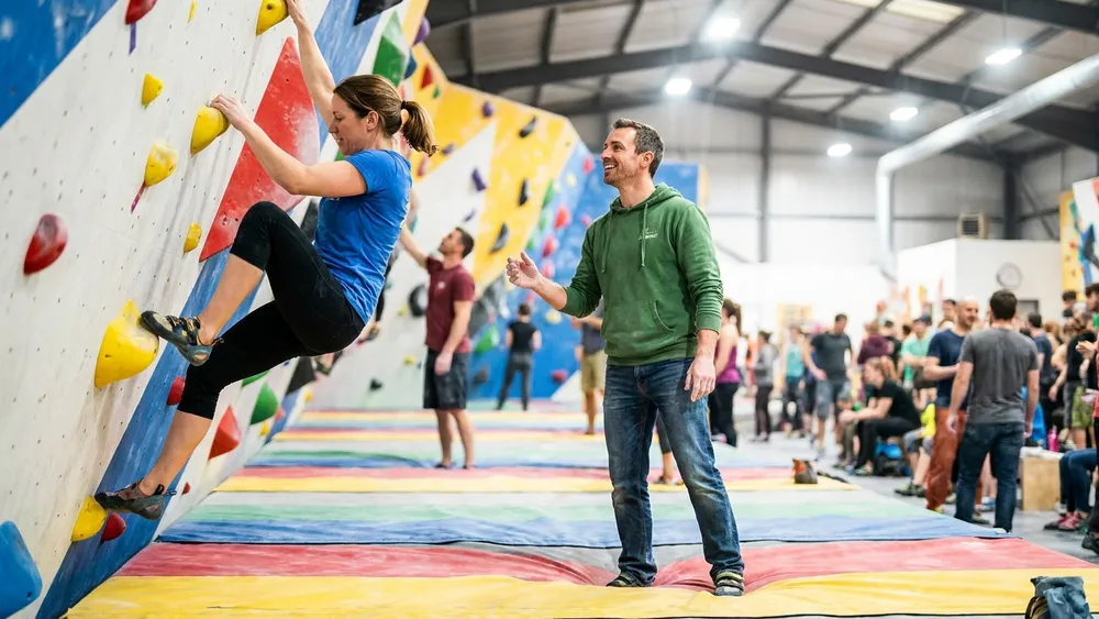urban apes Boulderhalle in Kiel - Erwachsene klettern an bunten Griffen in einer großen Halle