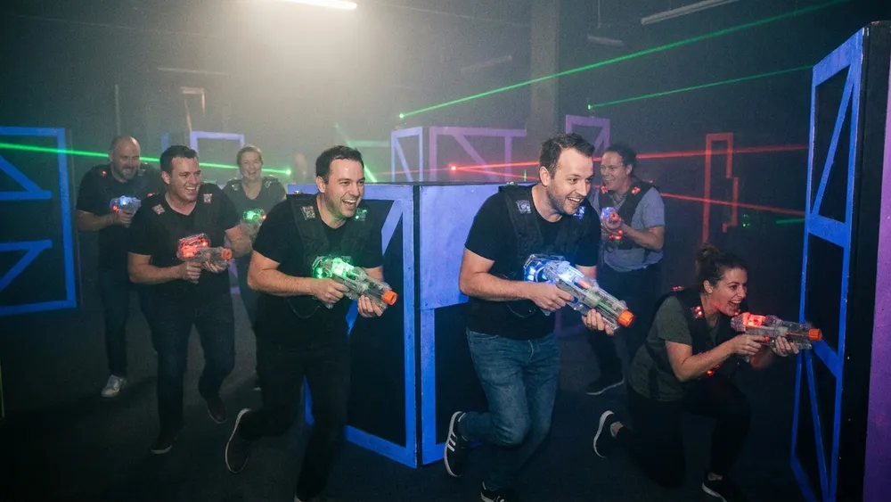LaserZone Kiel - Erwachsene mit Laserpistolen in einer neonbeleuchteten Arena