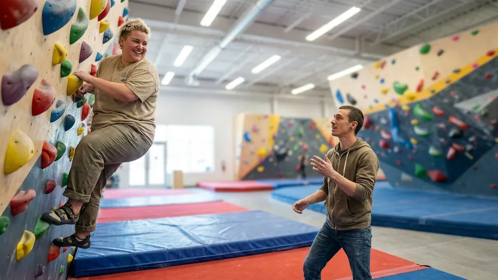 urban apes Kiel – Team bouldert gemeinsam in einer großen Halle mit bunten Klettergriffen