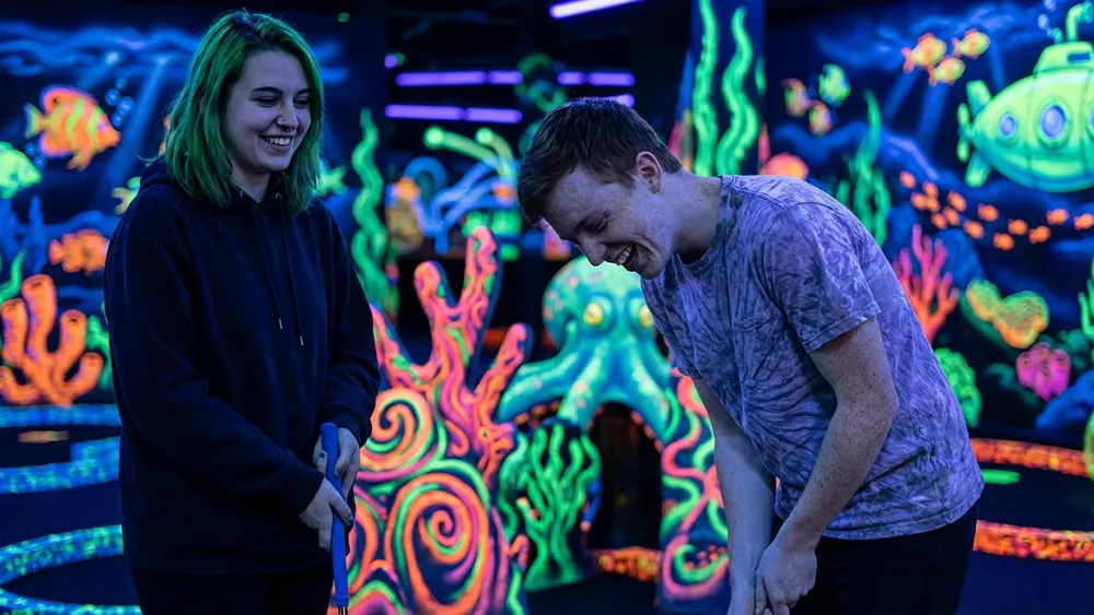 4D Schwarzlicht Minigolf Kiel – Team spielt Minigolf in leuchtenden Neonfarben