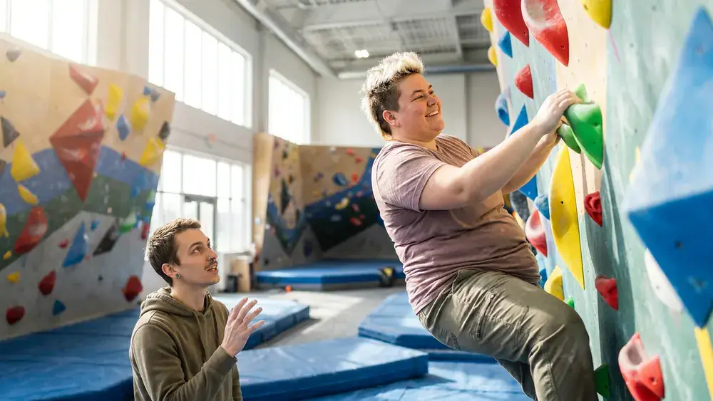 urban apes Boulderhalle in Kiel – Zwei Personen klettern an bunten Griffen in einer großen Halle
