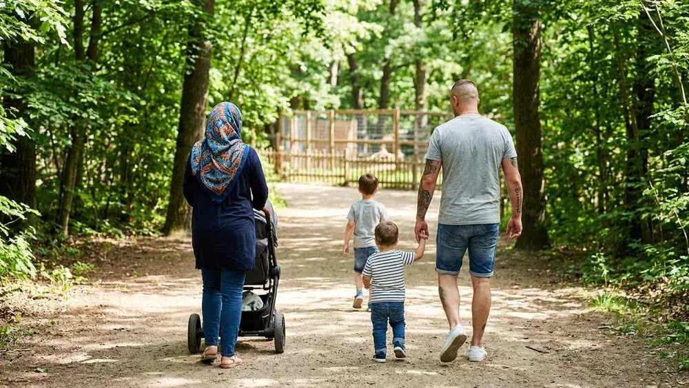 Tierpark Gettorf bei Kiel – Familie mit Kindern spaziert durch den Zoo mit bewaldeten Gehegen