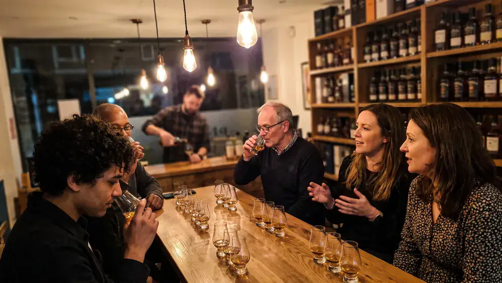 Whisky-Tasting in Kiel – Kollegen verkosten an einer Tafel mehrere Whiskys
