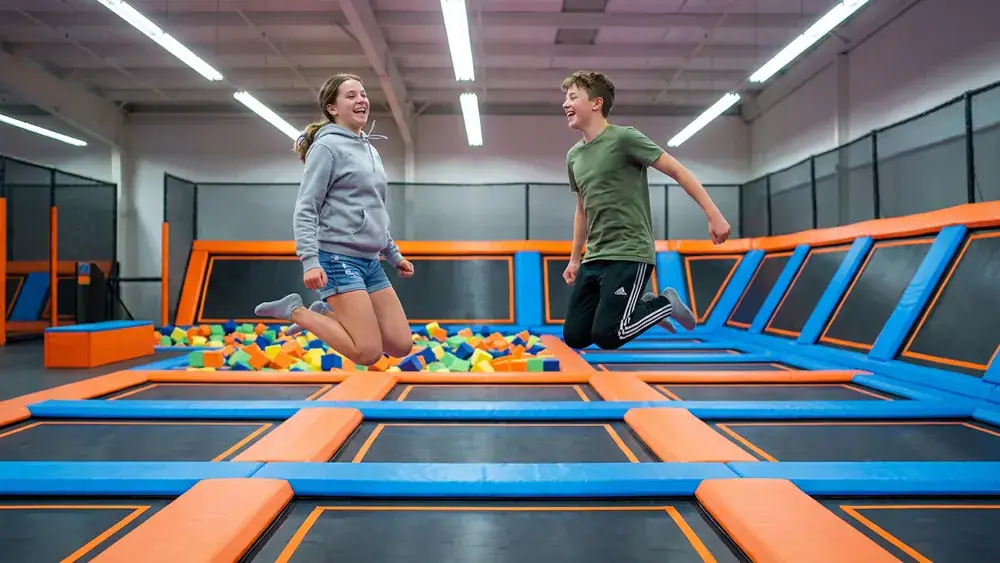 JUMP House Köln – Zwei Personen springen auf Trampolinen in einem bunten Indoor-Park