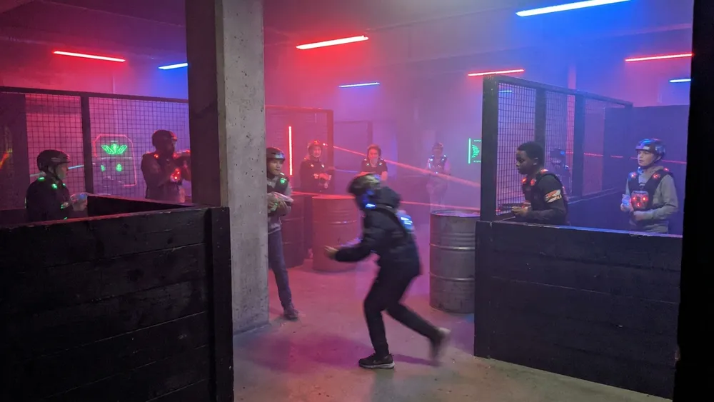 Lasertag in Köln – Gruppe mit Sensorwesten spielt in einer dunklen Neon-Arena