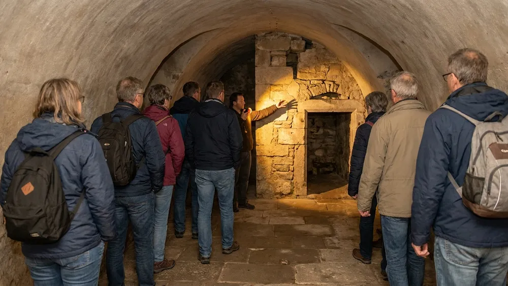 Unterirdisches Köln – Gruppe erkundet mit Stadtführerin ein mittelalterliches Kellergewölbe unter der Altstadt