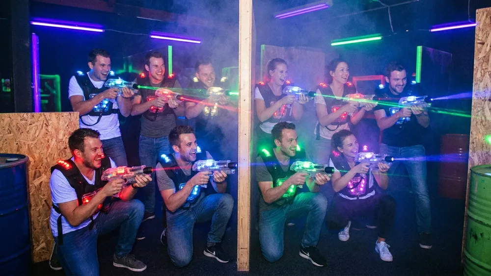 Lasertag in Köln - Erwachsene spielen in Teams in einer dunklen Neon-Arena