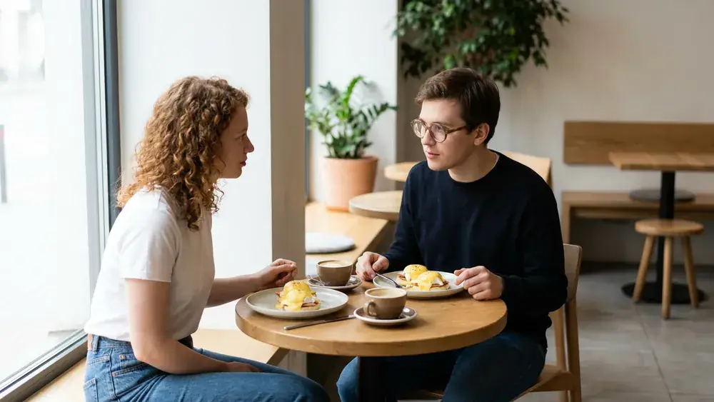 Café Balthasar in Köln – Zwei Personen brunchen mit Eggs Benedict und Kaffee im hellen Café