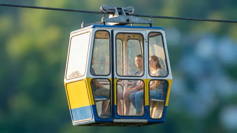 Kölner Seilbahn – Zwei Personen in einer Gondel über dem Rhein mit Blick auf die Stadt