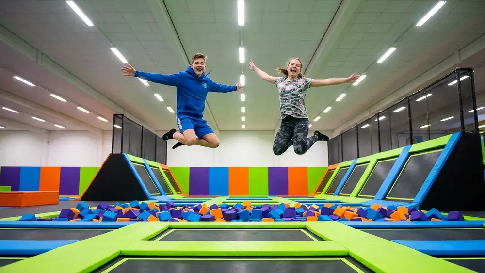 JUMP House Köln – Zwei Personen springen auf Trampolinen in einem bunten Indoor-Park