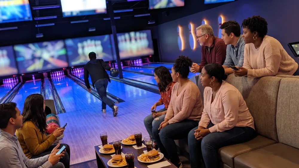 Bowling in Köln – Team jubelt an einer modernen Bowlingbahn bei West Bowling