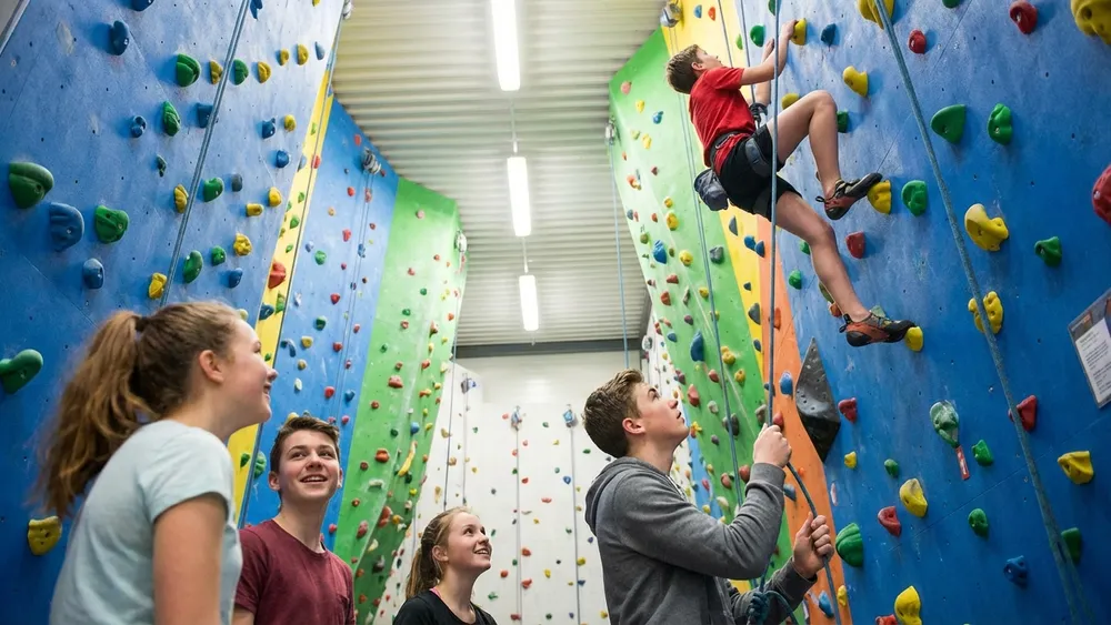 Kletterfabrik Köln – Schüler klettern an hohen Indoor-Kletterwänden mit Sicherung