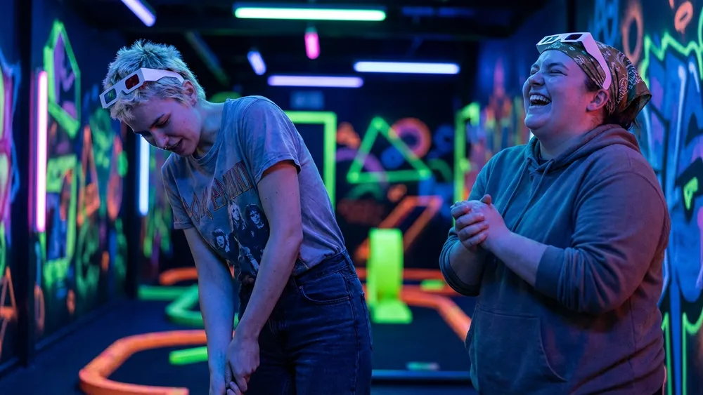 Blacklight Stuttgart – Zwei Personen spielen Schwarzlicht-Minigolf auf leuchtenden Neon-Bahnen