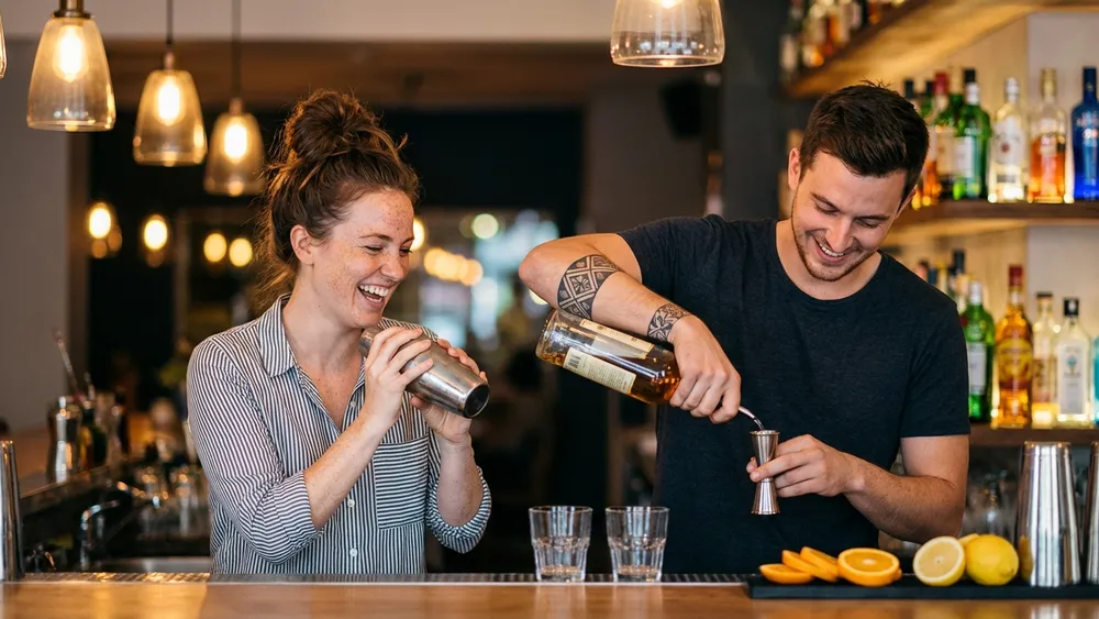 Cocktailkurs in Stuttgart – Zwei Personen mixen Cocktails an einer Bar unter Anleitung