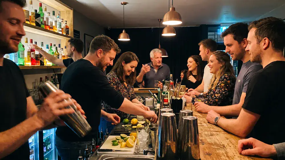 Cocktailkurs in Stuttgart – Kollegen mixen als Gruppe Cocktails an einer Bar unter Anleitung im SI-Centrum