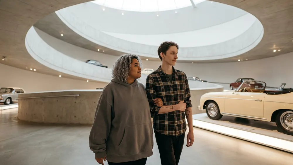 Mercedes-Benz Museum in Stuttgart – Zwei Personen gehen durch die spiralförmige Ausstellung mit Oldtimern