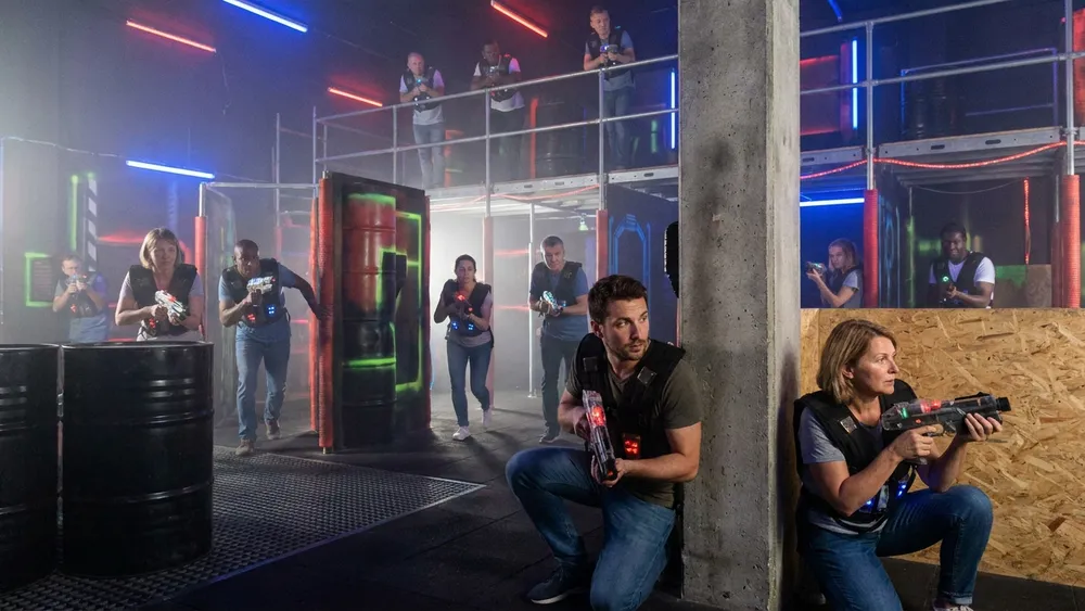 Lasertag in Stuttgart – Gruppe in Sensorwesten spielt mit Phasern in einer dunklen Neon-Arena
