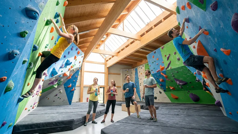 VELS Boulderhalle in Stuttgart - Erwachsene bouldern an bunten Kletterwänden in heller Halle