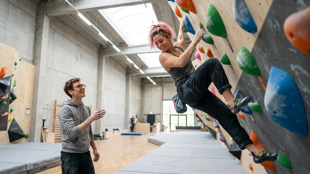 VELS Boulderhalle in Stuttgart – Team bouldert an bunten Kletterwänden in heller Halle