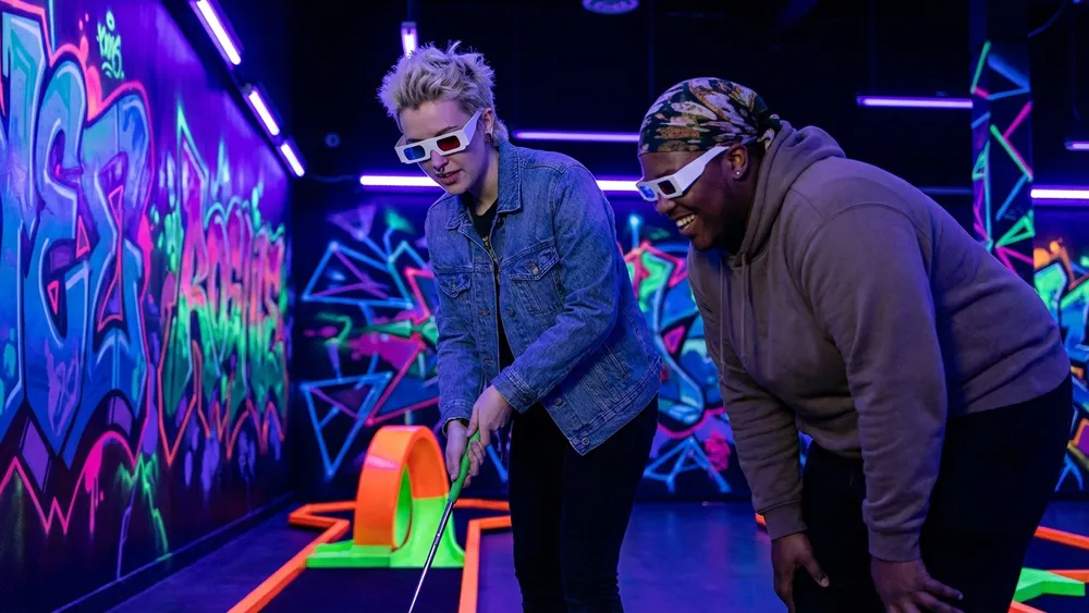 Schwarzlicht Minigolf in Stuttgart – Team spielt mit 3D-Brillen Minigolf in leuchtender Neonwelt