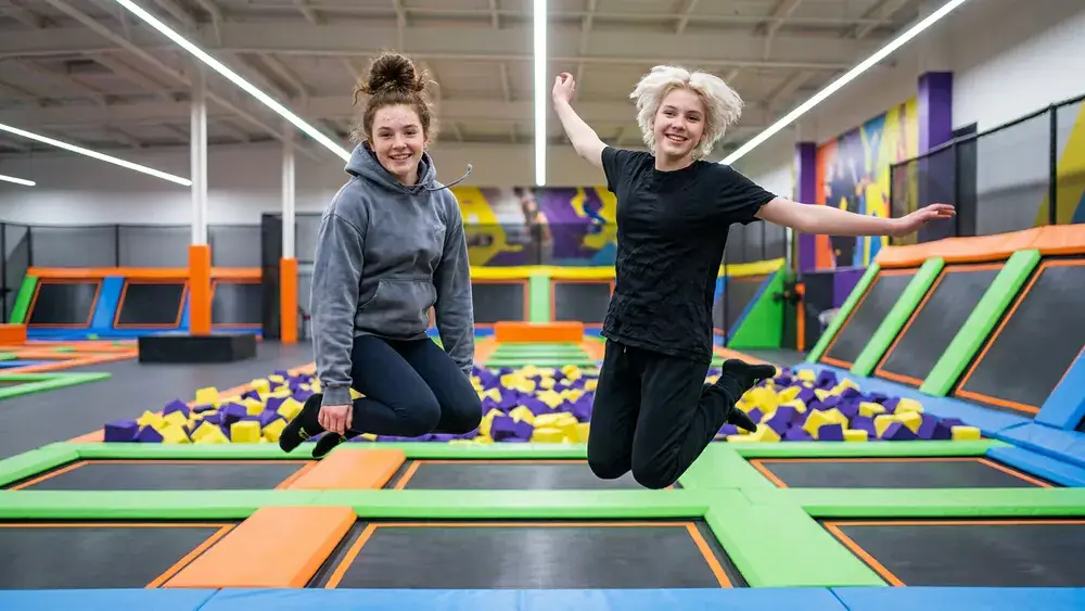 Sprungbude Stuttgart – Zwei Personen springen auf Trampolinen im Indoor-Park