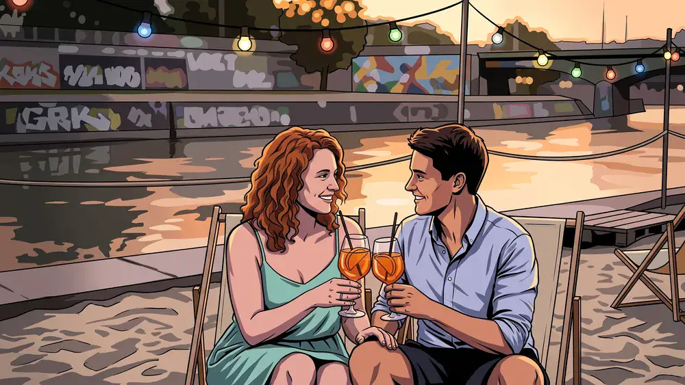 Donaukanal Wien – Zwei Personen sitzen mit Cocktails am Sandstrand der Strandbar Herrmann