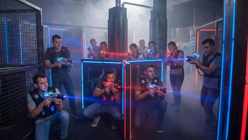 Lasertag in Wien – Gruppe mit Sensorwesten spielt in einer dunklen Neon-Arena im Prater
