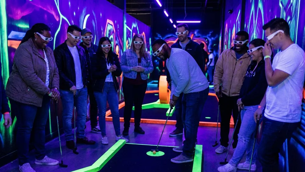 Schwarzlicht Minigolf in Wien – Gruppe spielt mit 3D-Brillen Minigolf in leuchtender Neonwelt