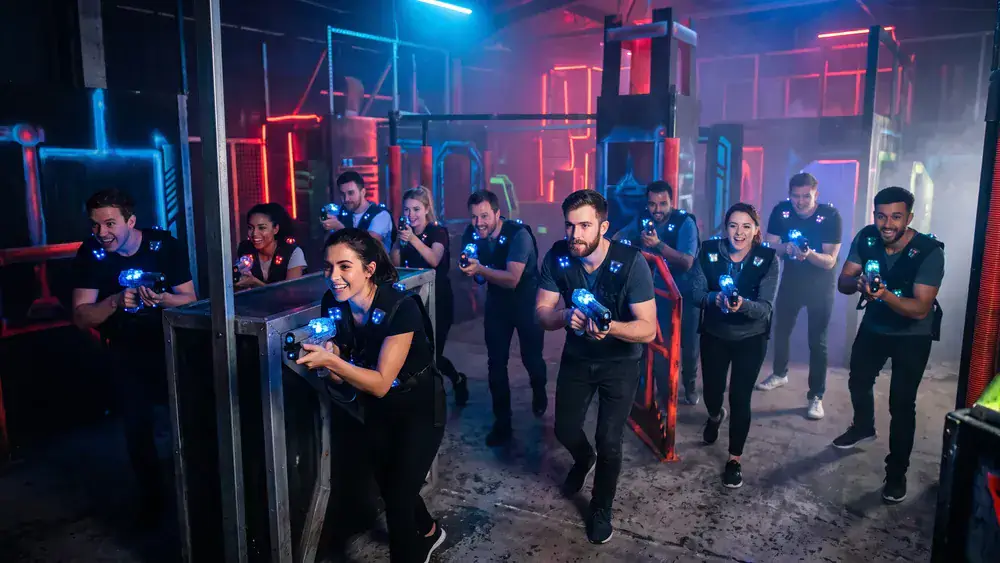Lasertag in Wien – Kollegen in tactical vests spielen bei der Weihnachtsfeier in einer dunklen Neon-Arena im Prater