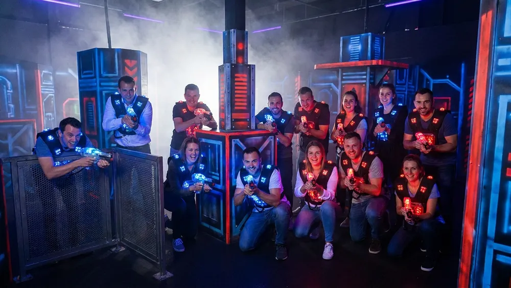 LaserTag Würzburg – Gruppe in taktischen Westen spielt in einer dunklen Neon-Arena am Hauptbahnhof