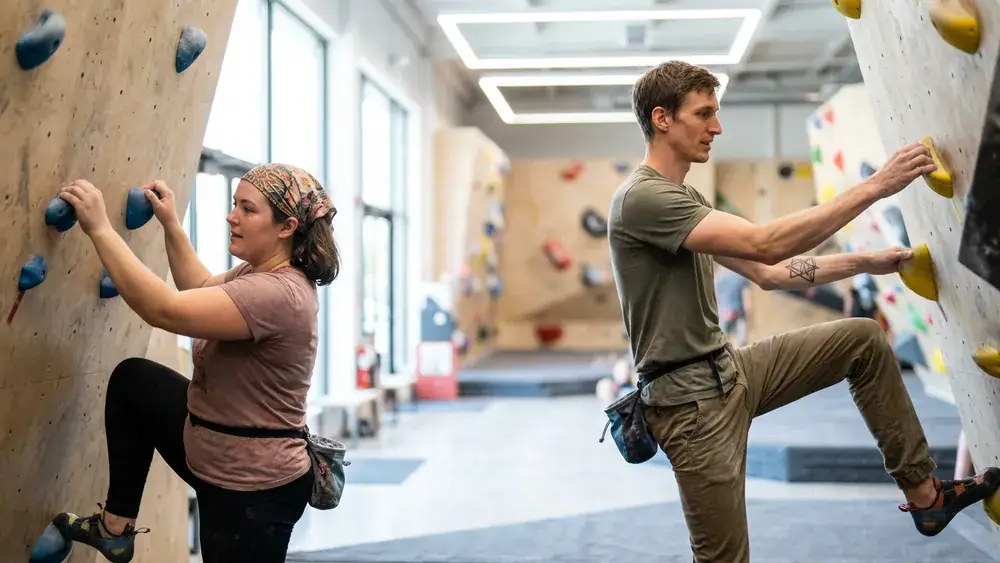 Rock Inn Boulderhalle Würzburg – Zwei Personen bouldern an einer bunten Kletterwand