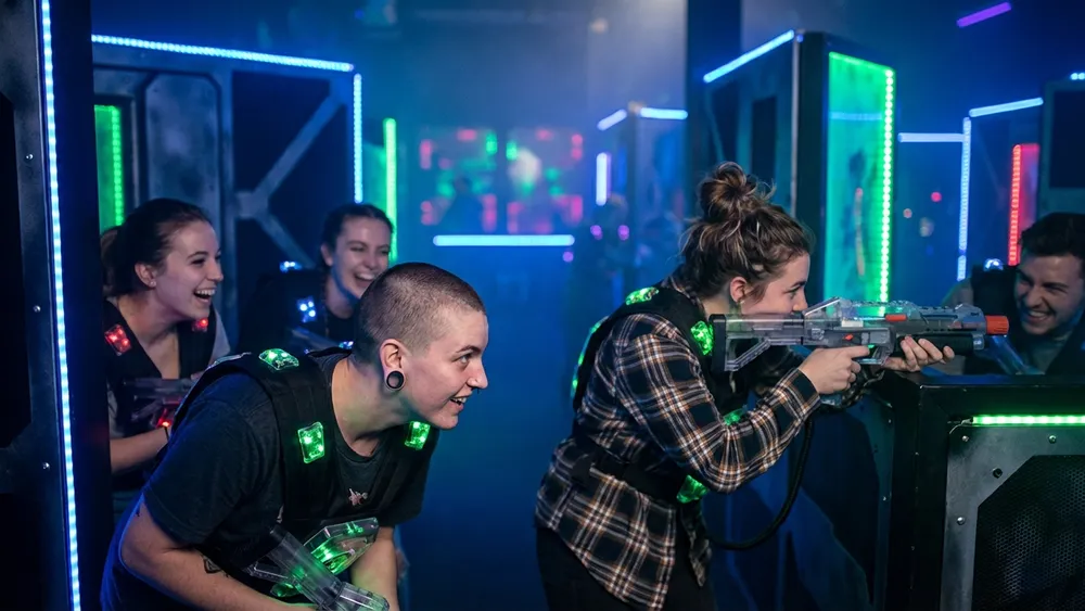 LaserTag Würzburg – Team in tactical vests spielt in einer dunklen Neon-Arena am Hauptbahnhof