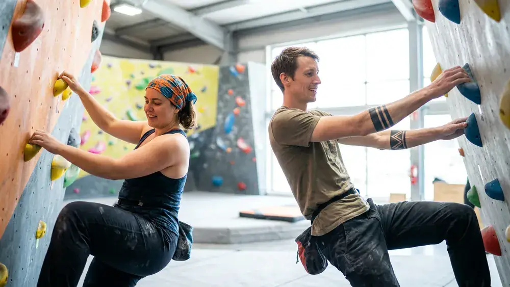 Rock Inn Boulderhalle Würzburg – Zwei Personen bouldern an einer bunten Kletterwand