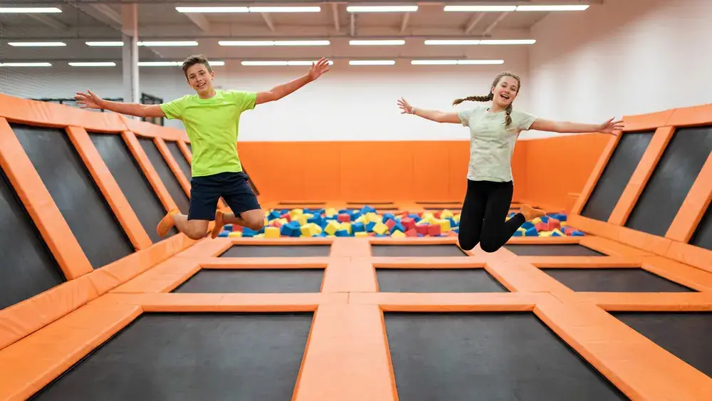 SkyandSand Trampolinhalle Würzburg – Zwei Jugendliche springen auf verbundenen Trampolinen