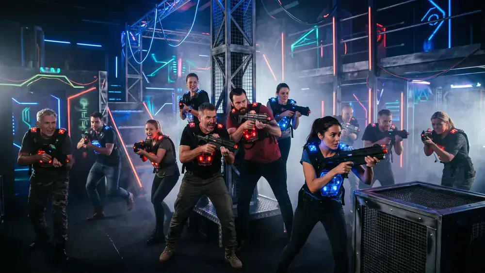LaserTag Würzburg – Kollegen in taktischen Westen spielen bei der Weihnachtsfeier in einer Neon-Arena